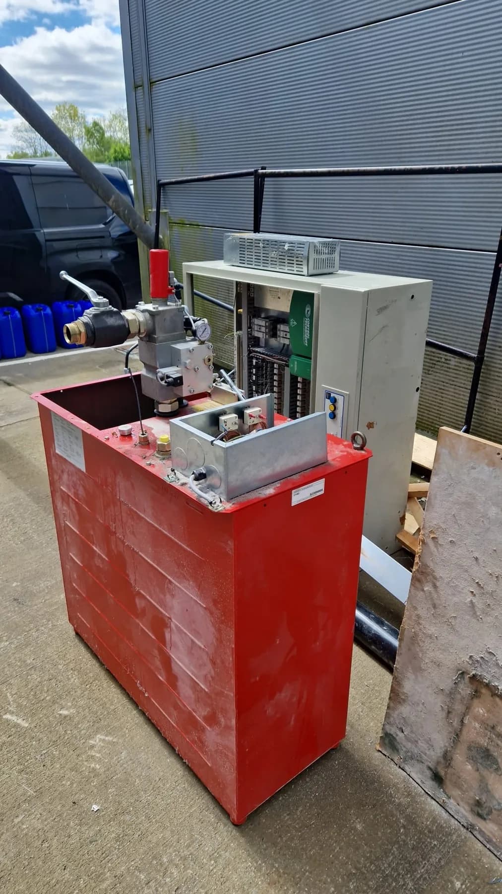 Red steel control cabinet and switchgear outside an industrial unit