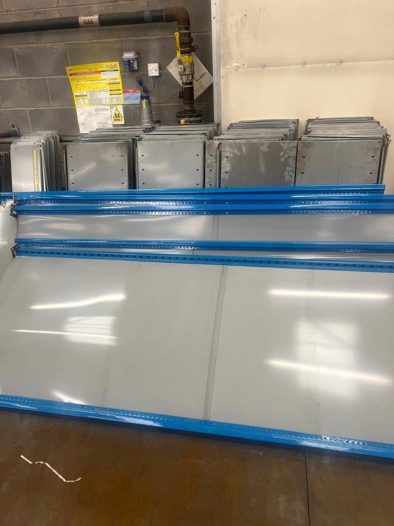 Stacked metal sheets with blue edges for scrap metal collection in Glasgow.